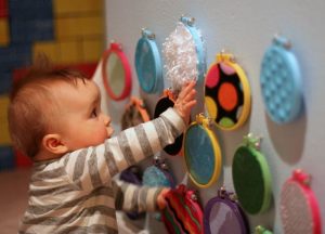 Little kid using touch sensation to discover different textures