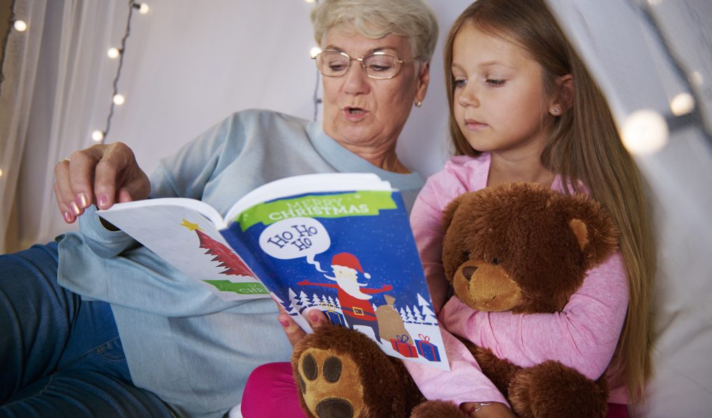 Grandmother reading stories out to her granddaughter- Babyhub