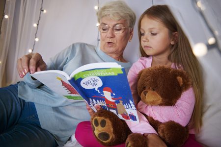 Grandmother reading stories out to her granddaughter- Babyhub