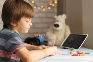 Screen time: A boy concentrating on his tasks with the help of screens - Babyhub